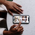 A smartphone user scrolls through photos on their screen